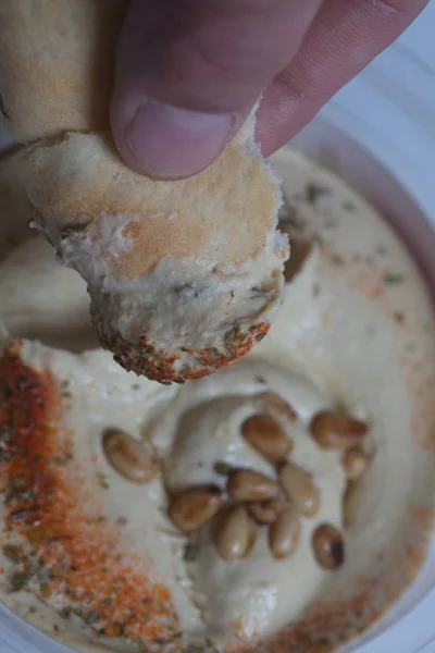 Hummus con nueces de cedro en el frasco y pita fresca —  Fotos de Stock