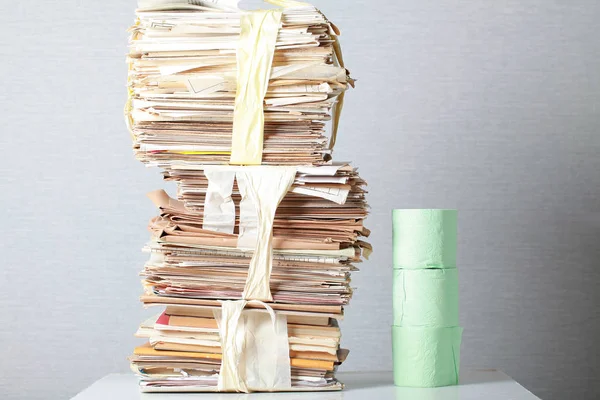 A stack of waste paper and a roll of toilet paper — Stock Photo, Image