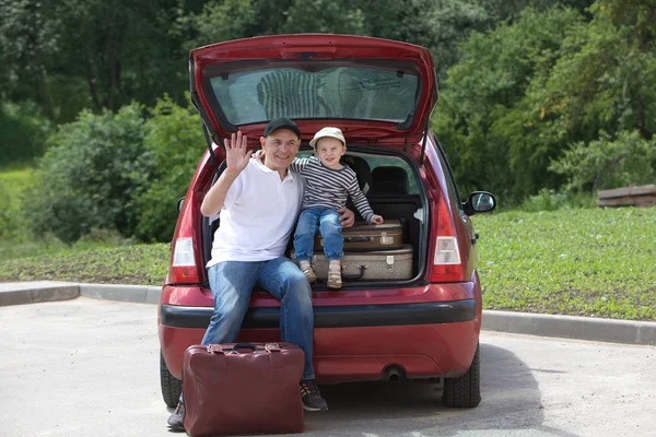 Muž a dítě načte jeho auto kufry — Stock fotografie