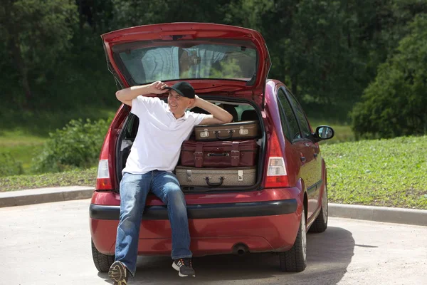 Un hombre carga las maletas de su coche — Foto de Stock