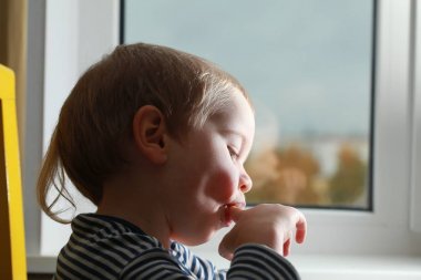 Komik bebek çocuk sarışın yalıyor parmak yoğurt ile