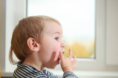 Komik bebek çocuk sarışın yalıyor parmak yoğurt ile