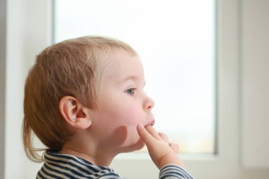 Komik bebek çocuk sarışın yalıyor parmak yoğurt ile