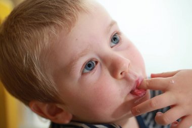Komik bebek çocuk sarışın yalıyor parmak yoğurt ile