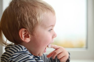 Komik bebek çocuk sarışın yalıyor parmak yoğurt ile