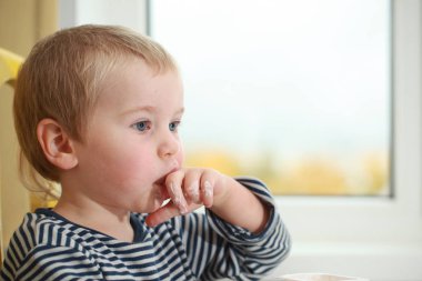 Komik bebek çocuk sarışın yalıyor parmak yoğurt ile