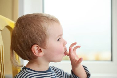 Komik bebek çocuk sarışın yalıyor parmak yoğurt ile