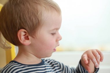 Komik bebek çocuk sarışın yalıyor parmak yoğurt ile