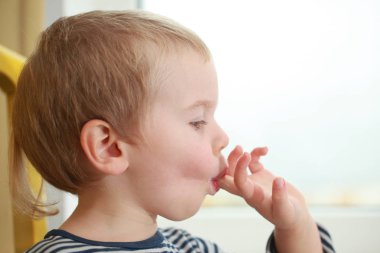 Komik bebek çocuk sarışın yalıyor parmak yoğurt ile