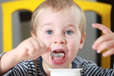 Komik bebek çocuk sarışın yalıyor parmak yoğurt ile