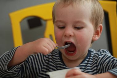 Komik bebek çocuk sarışın yalıyor parmak yoğurt ile