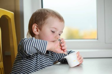 Komik bebek çocuk sarışın yalıyor parmak yoğurt ile