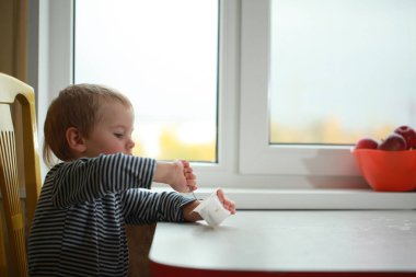 Komik bebek çocuk sarışın yalıyor parmak yoğurt ile