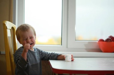 Komik bebek çocuk sarışın yalıyor parmak yoğurt ile