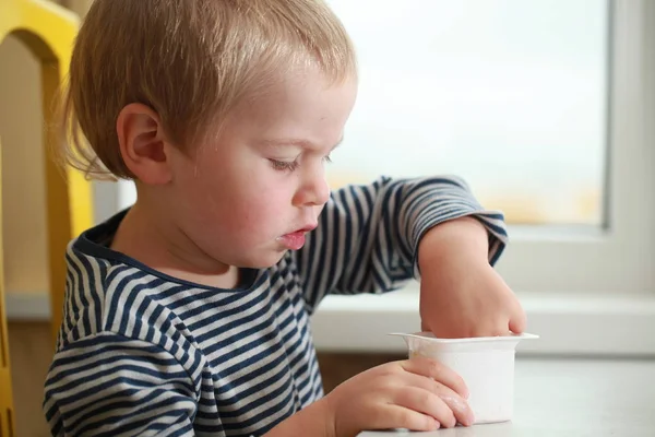 Komik bebek çocuk sarışın yalıyor parmak yoğurt ile