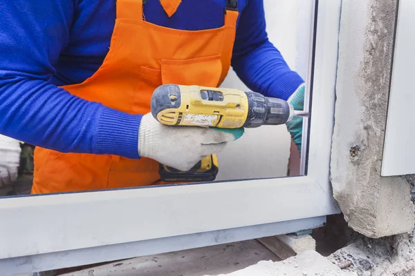 Der Arbeiter montiert Kunststofffenster und -türen — Stockfoto