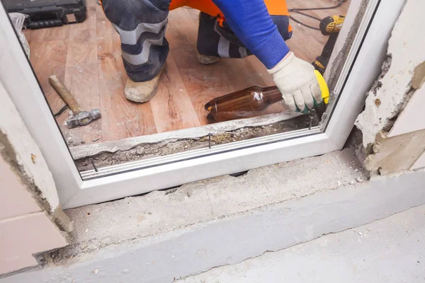 Der Arbeiter montiert Kunststofffenster und -türen — Stockfoto