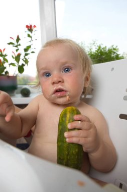 komik tombul sarışın çocuk evdeki mutfakta besleniyor.