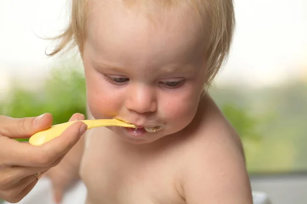 집 부엌에서 밥을 먹고 있는 우스운 처비 금발의 소년 — 스톡 사진