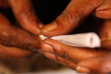 Zenci elleri marihuana sarmış. Yakından.