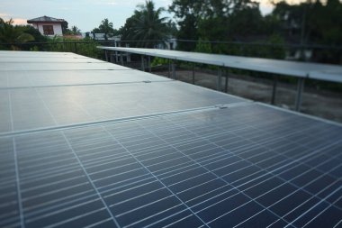 Sabahın erken saatlerinde tropik bir şehir evinin çatısındaki güneş panelleri..