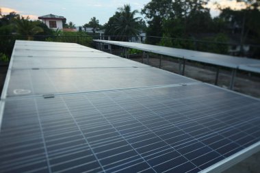 Sabahın erken saatlerinde tropik bir şehir evinin çatısındaki güneş panelleri..