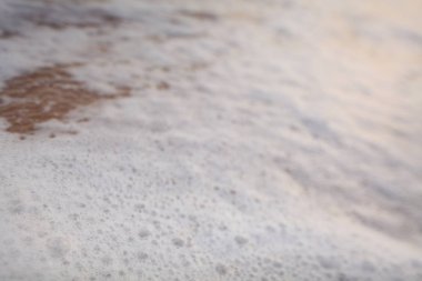 Kumlu tropikal okyanus sahilinde beyaz köpük