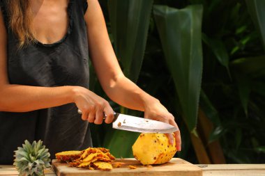 Taze olgun ananas doğrama kız elleri Tropik bir bahçe sri lanka 'sında ahşap bir masanın üzerinde
