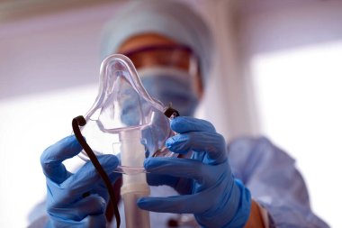 Korunma ekipmanındaki doktor oksijen maskeli hastaya koronavirüs teşhisi koydu.
