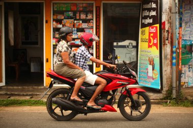Asyalı bir aile gün boyunca yolda motosiklet sürüyor. Sri Lanka, Hikkaduwa, 2020