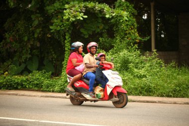 Asyalı bir aile gün boyunca yolda motosiklet sürüyor. Sri Lanka, Hikkaduwa, 2020