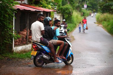 Asyalı bir aile gün boyunca yolda motosiklet sürüyor. Sri Lanka, Hikkaduwa, 2020