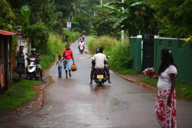 Asyalı bir aile gün boyunca yolda motosiklet sürüyor. Sri Lanka, Hikkaduwa, 2020