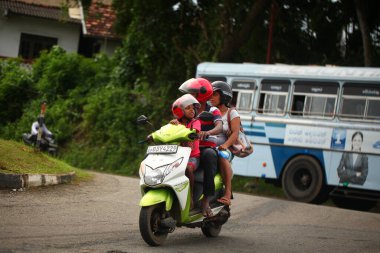 Asyalı bir aile gün boyunca yolda motosiklet sürüyor. Sri Lanka, Hikkaduwa, 2020