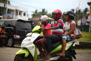 Asyalı bir aile gün boyunca yolda motosiklet sürüyor. Sri Lanka, Hikkaduwa, 2020