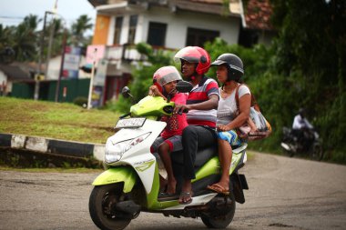 Asyalı bir aile gün boyunca yolda motosiklet sürüyor. Sri Lanka, Hikkaduwa, 2020