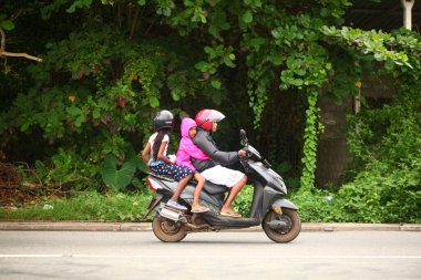Asyalı bir aile gün boyunca yolda motosiklet sürüyor. Sri Lanka, Hikkaduwa, 2020