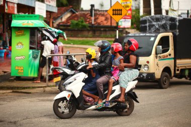 Asyalı bir aile gün boyunca yolda motosiklet sürüyor. Sri Lanka, Hikkaduwa, 2020