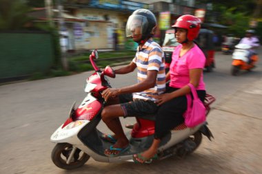 Asyalı bir aile gün boyunca yolda motosiklet sürüyor. Sri Lanka, Hikkaduwa, 2020