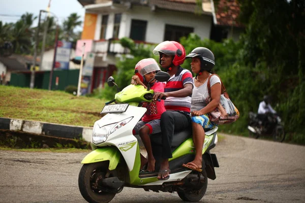 Asyalı bir aile gün boyunca yolda motosiklet sürüyor. Sri Lanka, Hikkaduwa, 2020