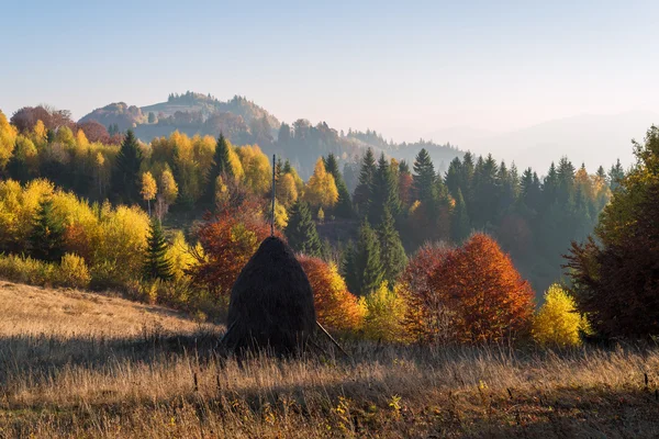 Herbstlandschaft mit Heuhaufen in den Bergen — Stockfoto