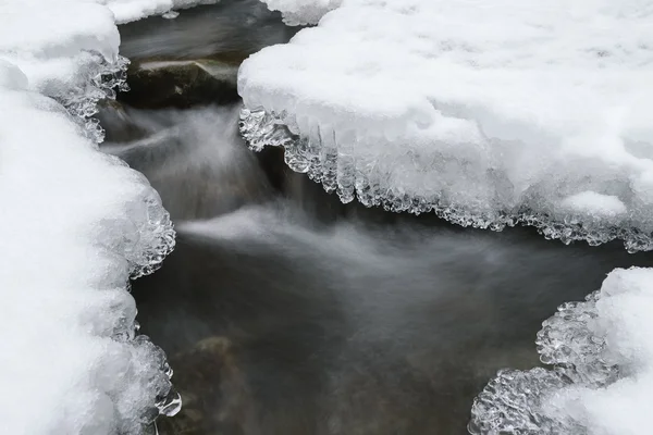 Hermosos carámbanos y nieve cerca del arroyo —  Fotos de Stock