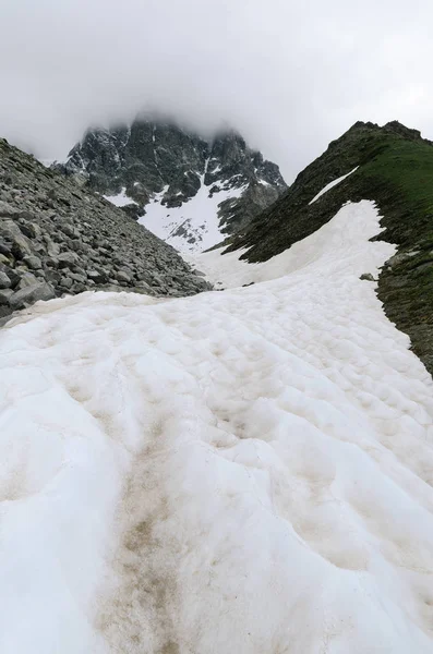 Paisagem de montanha com um campo de neve e morena — Fotografia de Stock