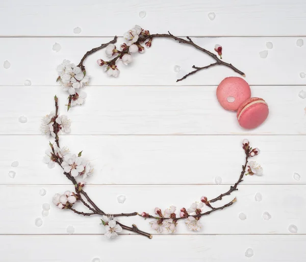 Marco decorativo de flores y macarrones sobre una espalda de madera blanca — Foto de Stock