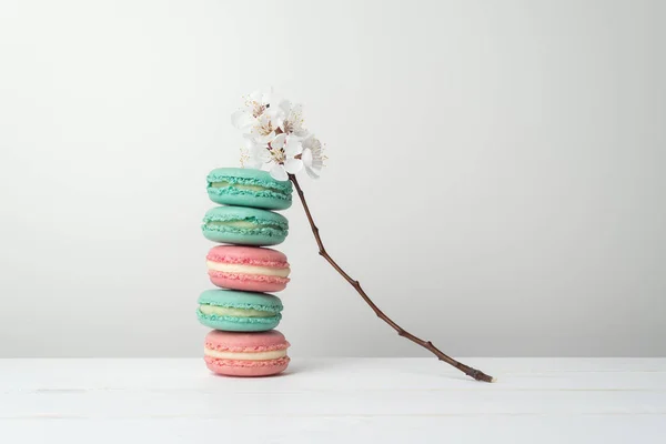 Печенье из макарон и ветка с белыми цветами — стоковое фото
