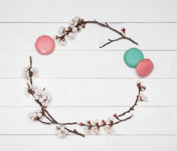 Decorative frame of flowers and almond cookies on a white wooden — Stock Photo, Image