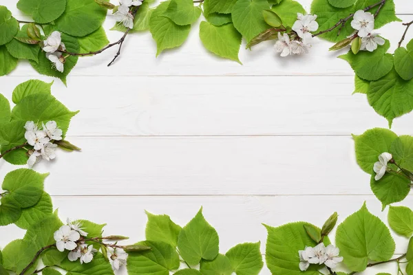 Decoratief frame van groene bladeren en witte bloemen — Stockfoto