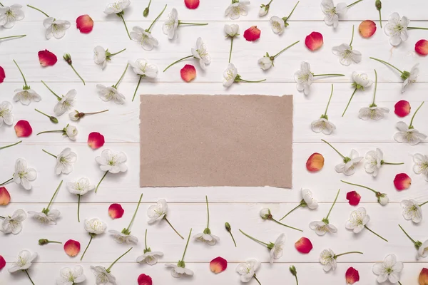Decoratief frame van witte cherry bloemen en rode bloemblaadjes — Stockfoto