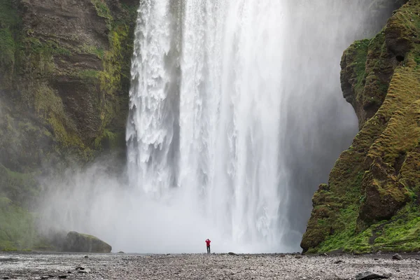 Turist nära Skogafoss vattenfall på Island — Stockfoto