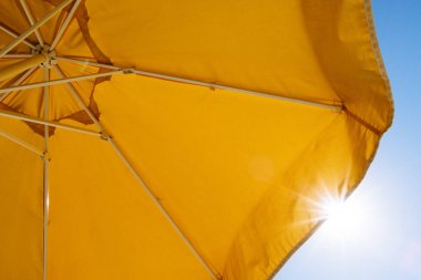 Sarı şemsiye ve güneş ışınlarının